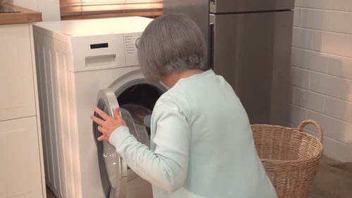 Woman Loading Laundry from Washing Machine at Home
