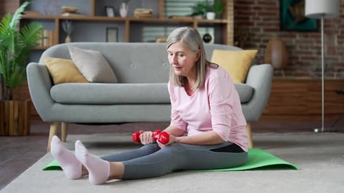 Senior Woman Working Out with Dumbbells in Home