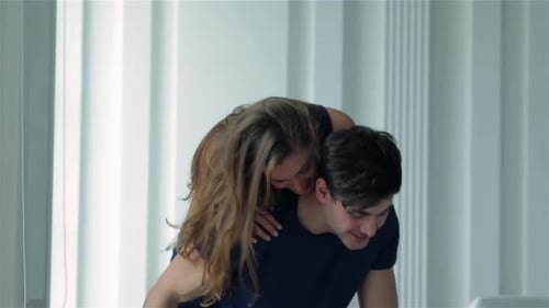 Woman Affectionately Embracing Man in Light Home Interior