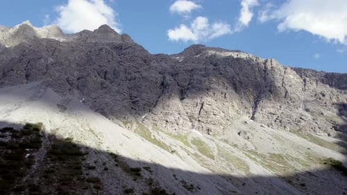Des images aériennes filmées par un Drone se tordent lentement pour révéler une crête épineuse et des sommets de montagnes au sommet de l'impo