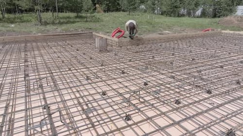 Man Working on Rebar Grid of Concrete Foundation