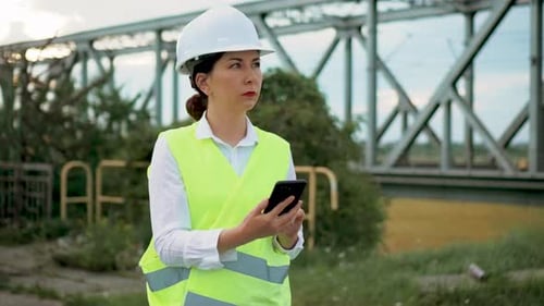 Engineer Inspects Bridge with Mobile Phone