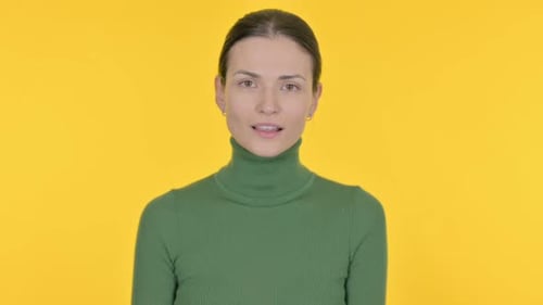 Woman Smiles and Gives Thumbs Up on Yellow
