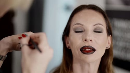 Artistic Makeup for Adult Woman Professional Makeup Artist Applying Lipstick on Lips Closeup View