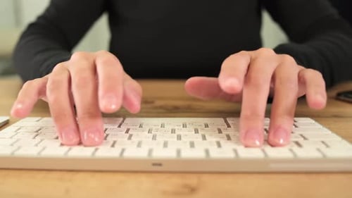 Young thoughtful business woman with glasses sitting indoors in office and typing on PC