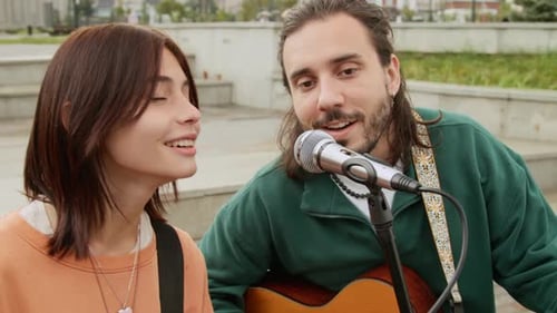 Dreamy Young Girl and Guy Singing Love Ballad while Performing in City Street