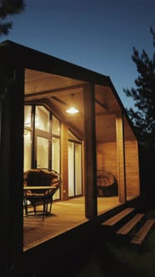 Cabin with illuminated porch at twilight