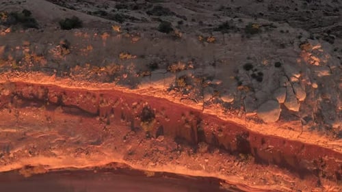 Golden Hour Glow Over Rugged Red Canyon Rocks And Cliffs