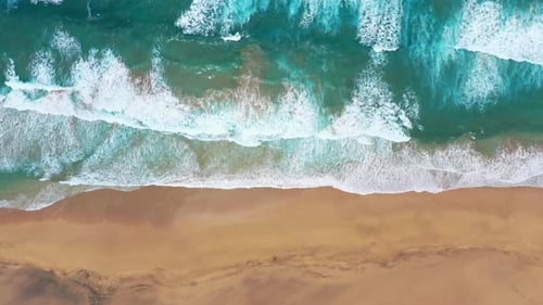 Aerial View of Ocean Waves on a Sandy Beach