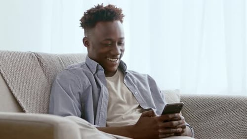 African American Guy Watching Videos on Mobile Phone