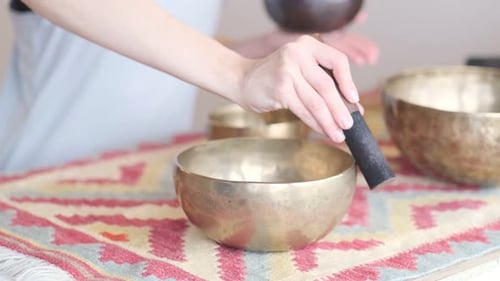 Woman Plays Brass Singing Bowl for Meditation