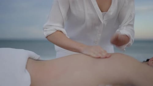 Close Up of Faceless Masseuse Patting Her Fingers on Her Clients Back in Healing Therapy Session