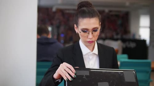 A Young Woman Comes in the Office and Starts Working