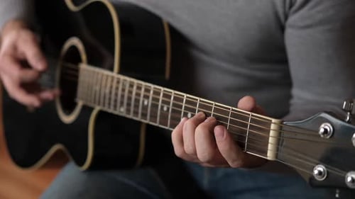 Person Playing Acoustic Guitar Close Up