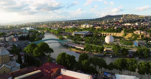 City Landmarks Of Tbilisi With The Bridge of Peace At Sunset In Georgia. Aerial Drone Shot
