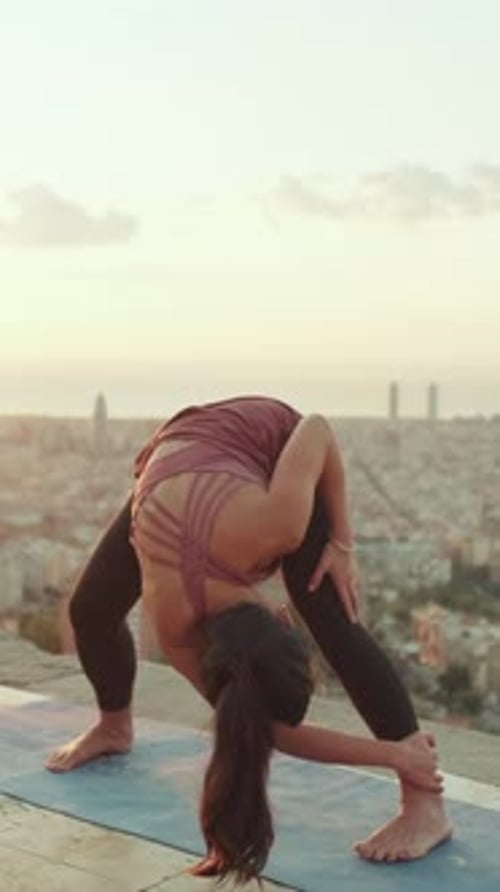 Girl stretching at dawn at lookout point on old town background