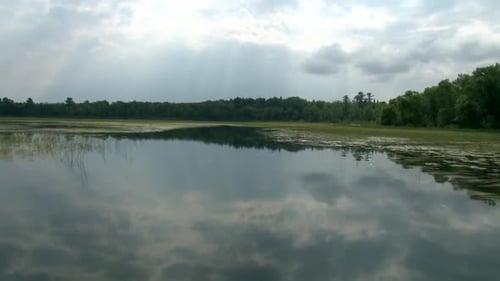 Calm Lake Reflecting Clouds in Rural Setting