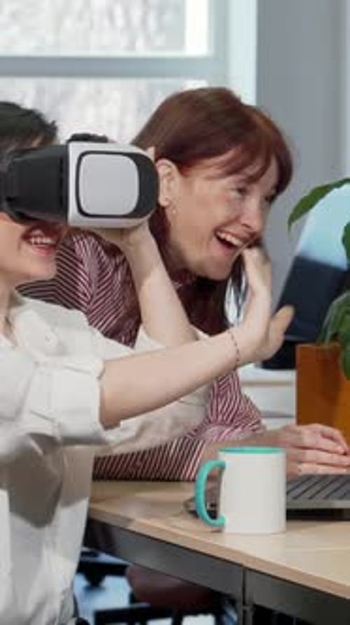 Two Female Colleagues Joyfully Exploring 3D VR Glasses at the Office