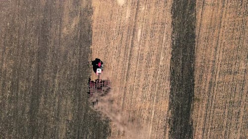 Farmer Plowing the Field with a Tractor