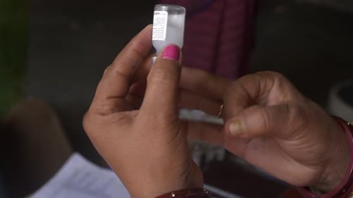 Professionnel de santé introduisant un médicament dans une seringue à partir d'un flacon, Pulse Polio Programme, Bihar