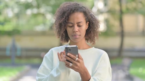 Woman Using Smartphone in Urban Park