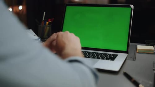 Hands Typing on Laptop with Green Screen at Desk