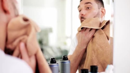 Man dries his face with a towel