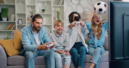 Cheerful Family Plays Video Game at Home