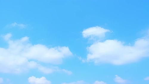 Fluffy Clouds Drifting Across Blue Sky Time-Lapse