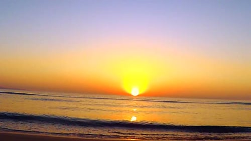 Radiant Sunrise Over Calm Ocean Waves