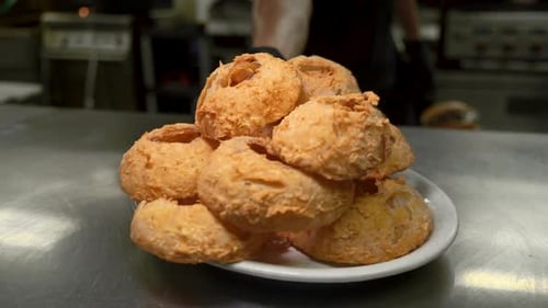 Deep fried onion rings piled high placed on pass by cook HD