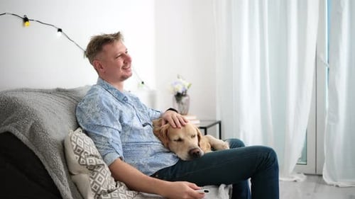 Man Relaxing with His Dog on Couch Indoors