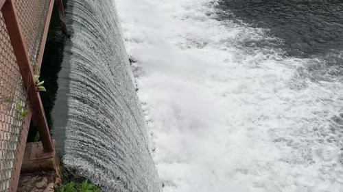 closeup of fast moving water thru a dam 4k 30fps drone angle