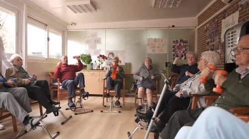 Senior Men and Women Doing Pedal Exercises and Lifting Dumbbells at Rehabilitation Center