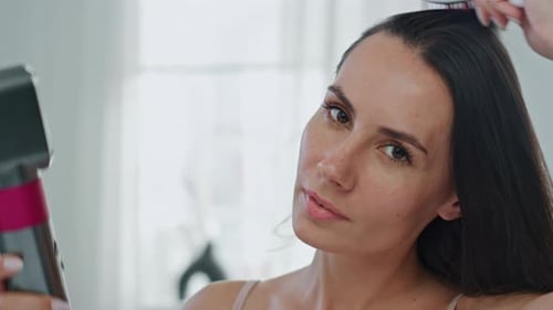 Woman Styling Her Long Dark Hair with Brush