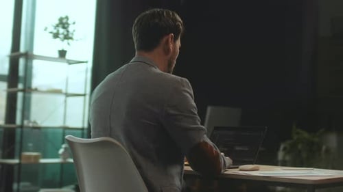 Man Working on Laptop in Modern Office Environment