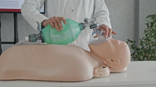 Doctor Demonstrating CPR Using Dummy