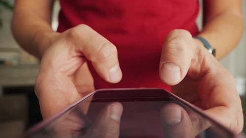 Close-up of man's fingers texting on mobile phone, chatting in social media.