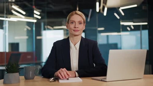 Smiling Woman at Desk in Modern Office