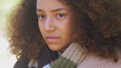 Pensive Young Woman with Curly Hair Looking Up