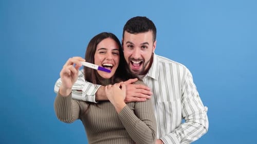 Happy Couple Holding Pregnancy Test Celebrating Good News