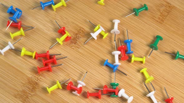 Colorful push pins rotating on the desk. Drawing pins for marking on ...