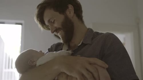 Loving Father Holding Newborn Baby Indoors