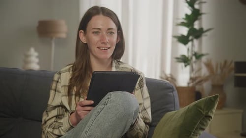 Woman Relaxing on Couch with Tablet Computer