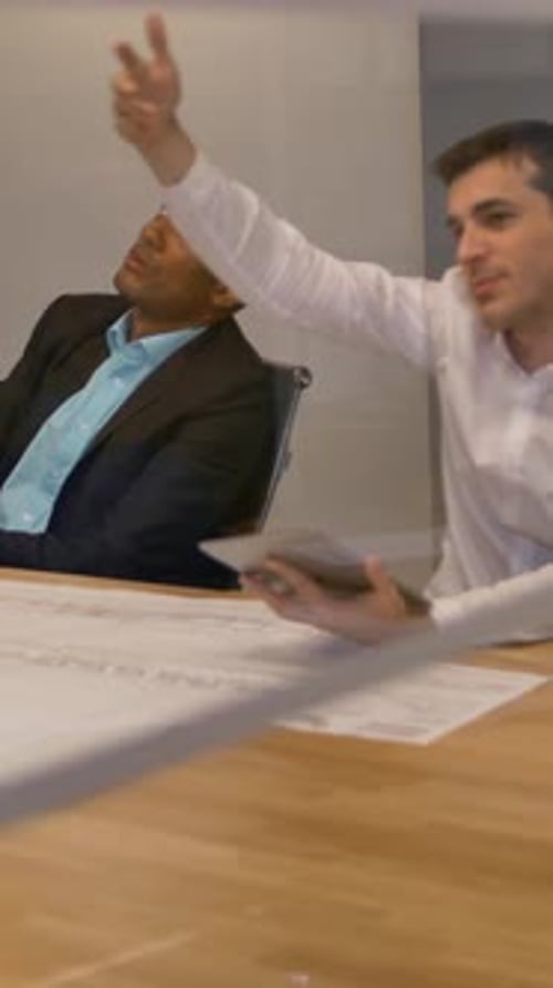 Vertical of Young Colleagues Team Sitting at a Table Man with Virtual Reality Goggles Testing