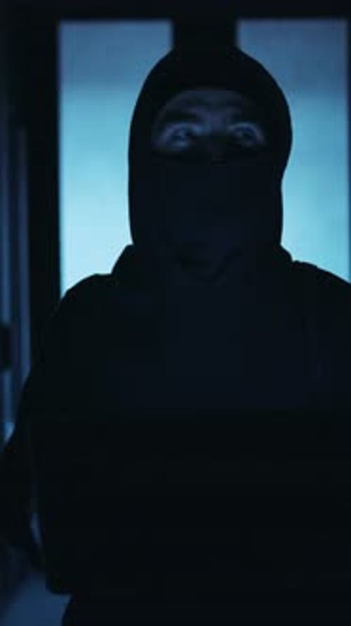 Hacker in Balaclava Typing at Computer at Night