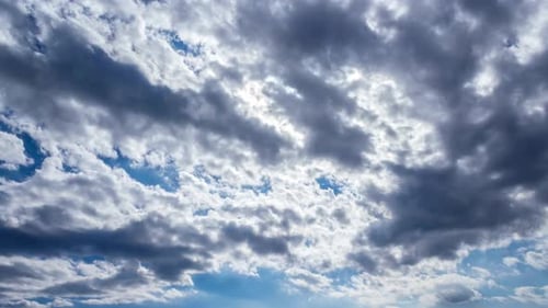Blue sky in day time. Dark clouds moving.