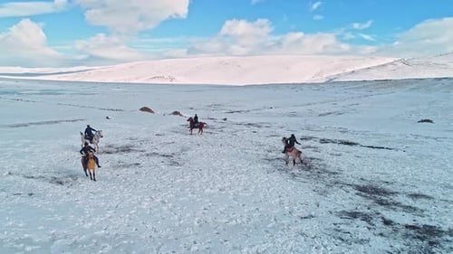 Horses and Riders Across Snowy Landscape