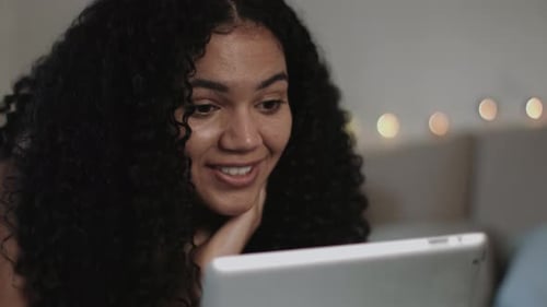 Smiling Woman Using Tablet for Video Call Indoors