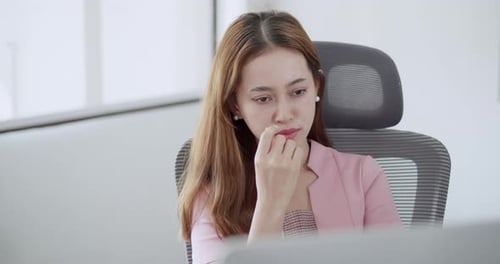 Introspective young woman working digital content in professional office space